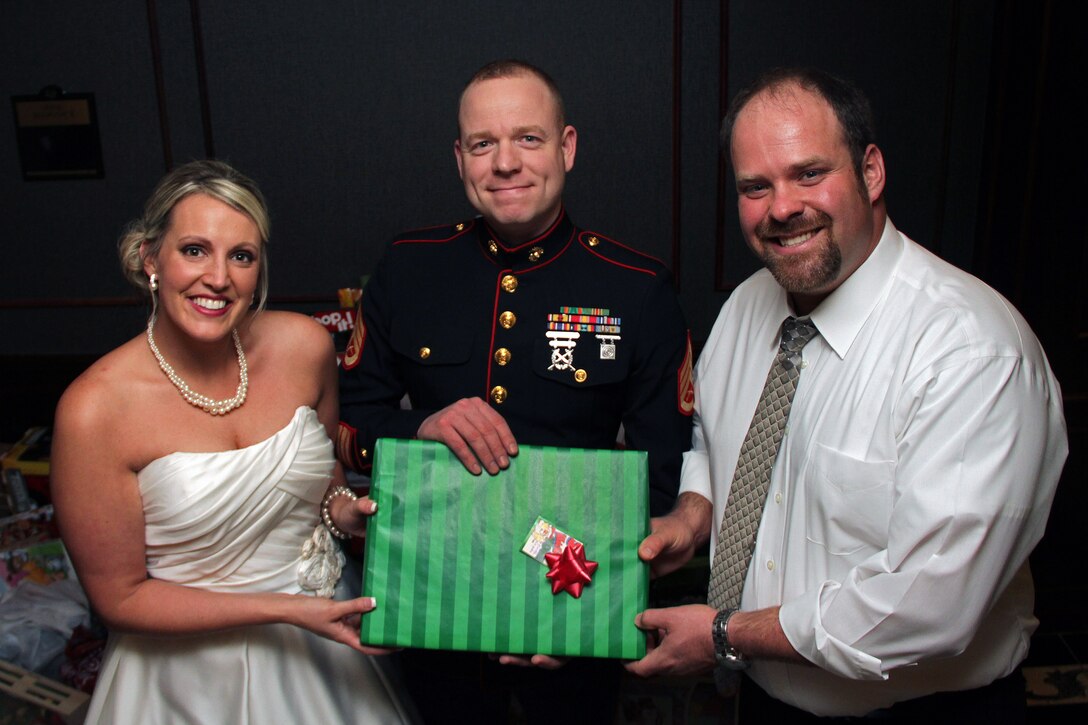 Staff Sgt. Eric M. Svedahl, 33, from Prior Lake, Minn., accepts a Christmas donation from Molly Schaefer and Nick Johnson during their wedding reception at the Grand Hotel Minneapolis Dec. 17. Instead of wedding gifts, the bride and groom asked everyone to bring a present for Toys for Tots. Overall, the newlyweds collected more than 100 donations. Svedahl is a recruiting support staff non-commissioned officer with Recruiting Station Twin Cities. For additional Toys for Tots imagery, visit www.facebook.com/rstwincities.