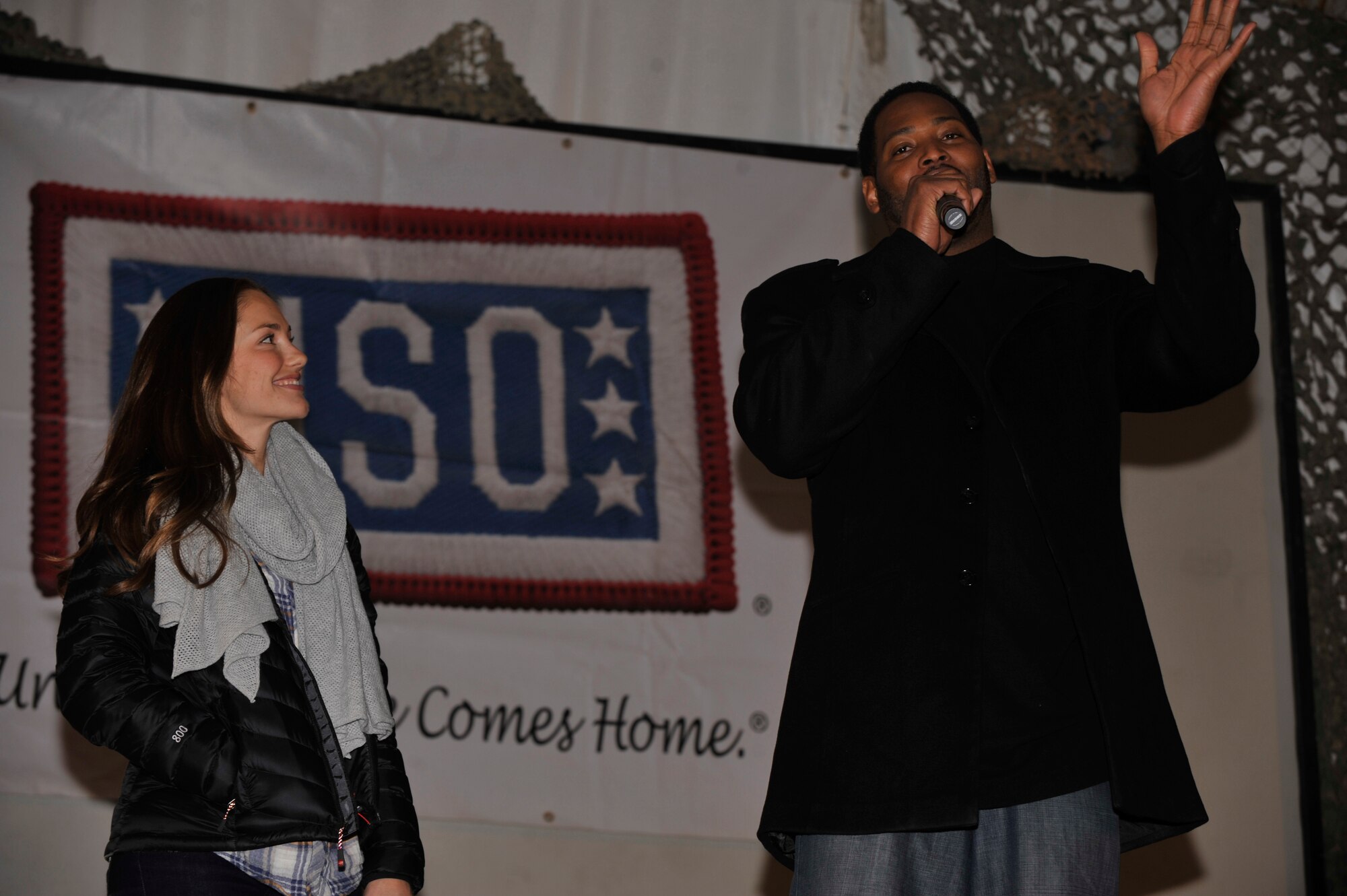 BAGRAM AIRFIELD, Afghanistan— Actor Minka Kelly and retired NBA star Robert Horry speak at the at the Morale, Welfare and Recreation clamshell at Bagram Airfield, Afghanistan, Dec. 16, 2011. Kelly and Horry where a part of the United Services Organization Holiday Tour, also included in the program were Jordan Sparks and Nephew Tommy. (U.S. Air Force photo/Airman 1st Class Ericka Engblom)