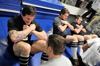 From left to right, Rampage hockey teammates Jeff LoVecchio, left wing, Keith Seabrook, defenseman, and David Marshall, forward, perform sit ups during the fitness challenge against pararescue and combat controller trainees at the Warhawk Fitness Center Dec. 13. (U.S. Air Force photo/Antonio Morano)