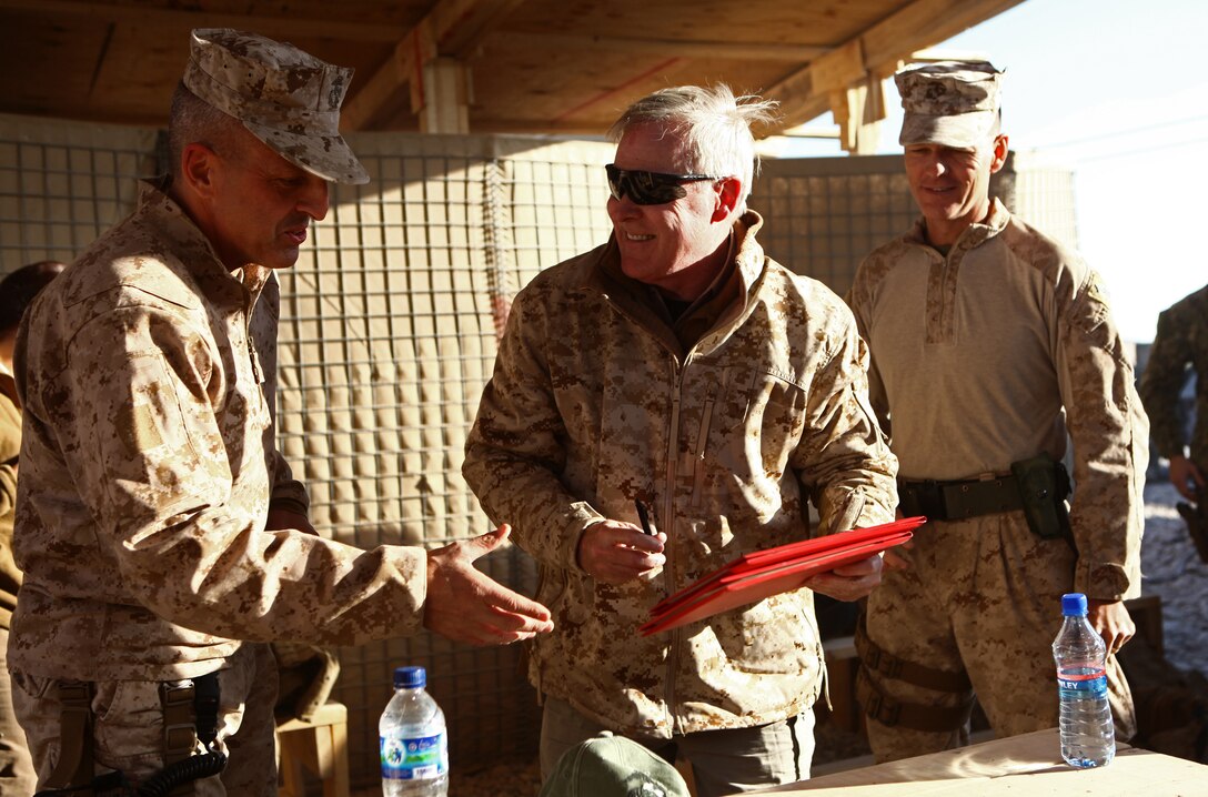 Brig. Gen. Michael Dana (left), commanding general of the 2nd Marine Logistics Group (Forward), and Sgt. Maj. William Stables (right), sergeant major of the 2nd MLG (FWD), provide Secretary of the Navy Ray Mabus with two Navy and Marine Corps Achievement Medals to present to two Marines aboard Forward Operating Base Nolay, Dec. 18. Sgt. Stacy McGuffin, of Havelock, N.C. and Cpl. Clinton Haller, of Olympia, Wash., were honored to receive recognition by the Navy's senior civilian leader. (U.S. Marine Corps Photo by Cpl. Michael Augusto)