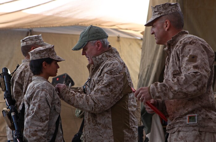 Secretary of the Navy Ray Mabus (middle) and Brig. Gen. Michael Dana (right), commanding general of the 2nd Marine Logistics Group (Forward), award two Marines with the Navy and Marine Corps Achievement Medals aboard Forward Operating Base Nolay, Dec. 18. Mabus visited the 2nd MLG assets at Nolay in order to see Marines and Sailors of Operation Enduring Freedom. (U.S. Marine Corps Photo by Cpl. Michael Augusto)