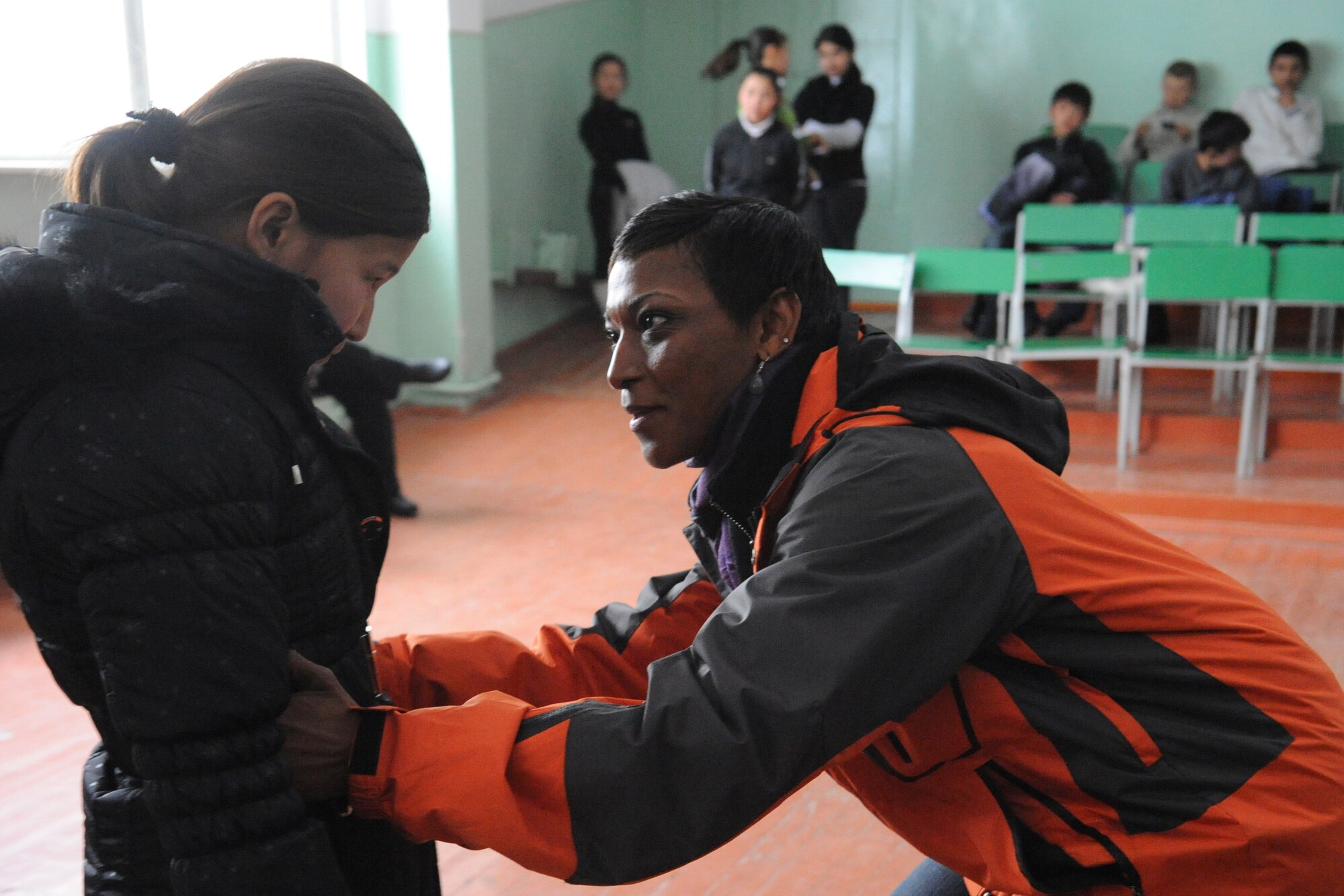 Senior Master Sgt. Rita Johnson checks the fit of a girl’s jacket on a girl at the Manas Village School, Kyrgyzstan, during the first Operation Warm and Dry delivery of the year Dec. 17, 2011. Operation Warm and Dry is a Transit Center at Manas humanitarian assistance program which provides blankets and coats to "at-risk" populations of Kyrgyzstan. Johnson is the 376th Expeditionary Medical Group superintendent deployed here from Joint Base Elmendorf-Richardson, Alaska. (U.S. Air Force photo/Tech. Sgt. Tammie Moore)    