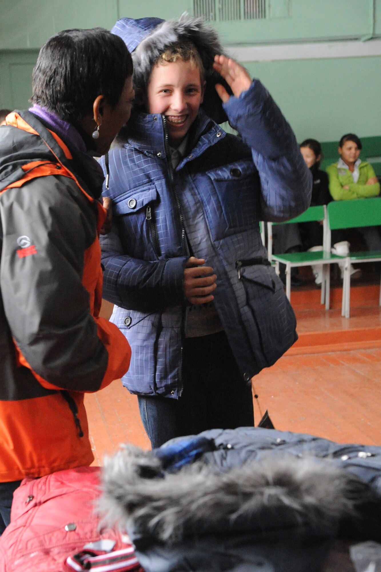 Senior Master Sgt. Rita Johnson talks to a boy at the Manas Village School, Kyrgyzstan, about his new jacket during the first Operation Warm and Dry delivery of the year Dec. 17, 2011. Operation Warm and Dry is a Transit Center at Manas humanitarian assistance program which provides blankets and coats to "at-risk" populations of Kyrgyzstan. Johnson is the 376th Expeditionary Medical Group superintendent deployed here from Joint Base Elmendorf-Richardson, Alaska. (U.S. Air Force photo/Tech. Sgt. Tammie Moore)    