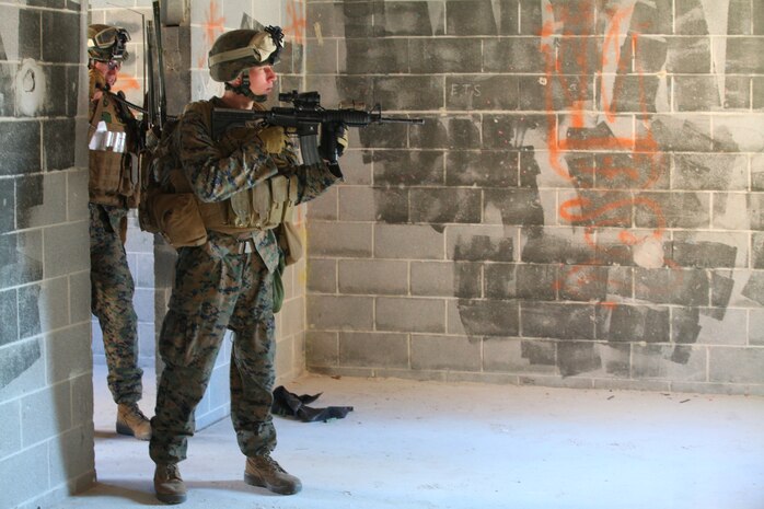 1st Lt. Michael Moore, platoon commander of 1st Platoon, Bravo Company, Battalion Landing Team 1st Battalion, 2nd Marine Regiment, 24th Marine Expeditionary Unit, passes orders over the radio while his Marines post security during a raid training scenario at the Military Operations in Urban Terrain training facility aboard Camp Lejeune, Dec. 18. The Marines were inserted on Camp Lejeune from amphibious ships of Amphibious Squadron 8 (PHIBRON 8) positioned 3-5 miles off the coast of North Carolina with the task of assaulting an enemy position inland.  The training was a culminating event as part of Composite Training Unit Exercise (COMPTUEX), a three-week exercise with 24th MEU embarked at sea to develop cohesion with PHIBRON 8 in conducting amphibious operations, crisis response, and limited contingency operations while operating from the sea.