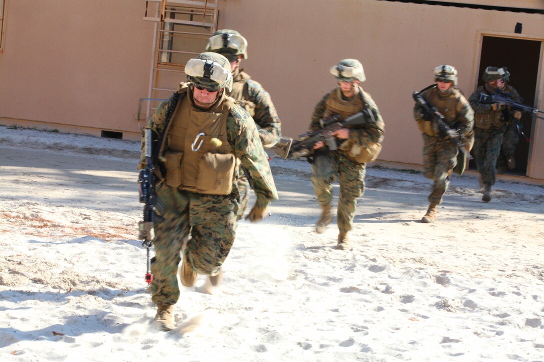 Marines with Bravo Company, Battalion Landing Team 1st Battalion, 2nd Marine Regiment, 24th Marine Expeditionary Unit, rush toward a building at the Military Operations in Urban Terrain training facility aboard Camp Lejeune, during a raid training scenario Dec. 18. The Marines were inserted on Camp Lejeune from amphibious ships of Amphibious Squadron 8 positioned 3-5 miles off the coast of North Carolina with the task of assaulting an enemy position inland.  The training was a culminating event as part of Composite Training Unit Exercise (COMPTUEX), a three-week exercise with the 24th MEU embarked at sea to develop cohesion Amphibious Squadron 8 (PHIBRON 8) in conducting amphibious operations, crisis response, and limited contingency operations while operating from the sea.