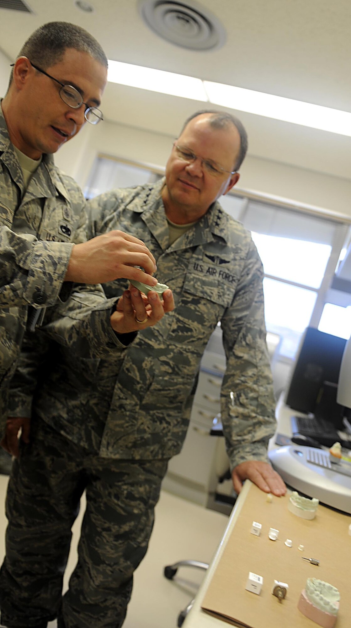 U.S. Air Force Tech. Sgt. Steve Lovato, 18th Dental Squadron dental laboratory craftsman, talks with U.S. Air Force Lt. Gen. Charles Green, U.S. Air Force Surgeon General, about what the 18th DS Airmen provide patients with at Kadena Air Base, Japan, Dec. 16, 2011. Green is visiting all U.S. Air Force bases in Japan. (U.S. Air Force photo by Airman 1st Class Brooke P. Beers/Released)