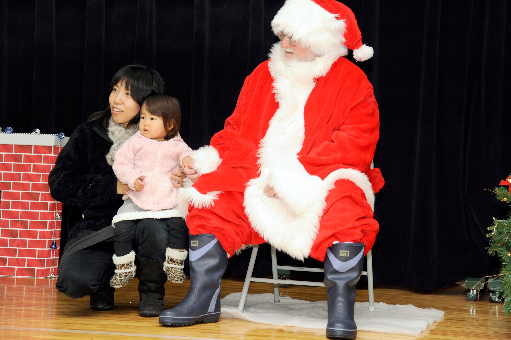 MISAWA AIR BASE, Japan - Kanako Wakaki and her daughter Haruko meet Santa Claus during the Misawa Holiday Lights Tour here, Dec. 17. More than 500 Japanese adults and children from the local community participated in this year's tour, which allowed them to enjoy holiday lights and decorations, arts and crafts, hot chocolate and cookies, and pictures with Santa Claus. (U.S. Air Force photo/Tech. Sgt. Marie Brown)