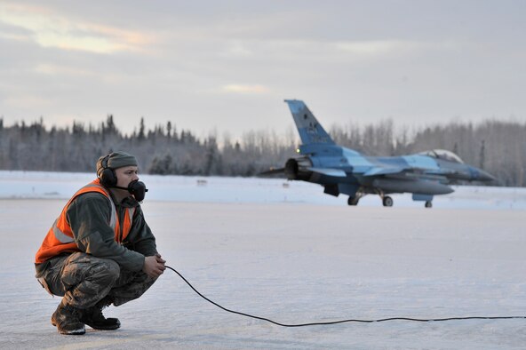 U.S. Air Force Staff Sgt. Shawn Ryherd waits for an F-16 Fighting Falcon to approach for its last inspections before takeoff Dec. 19, 2011, Eielson Air Force Base, Alaska. Ryherd is a crew chief assigned to the 354th Aircraft Maintenance Squadron. (U.S. Air Force photo by Staff Sgt. Christopher Boitz/Released)