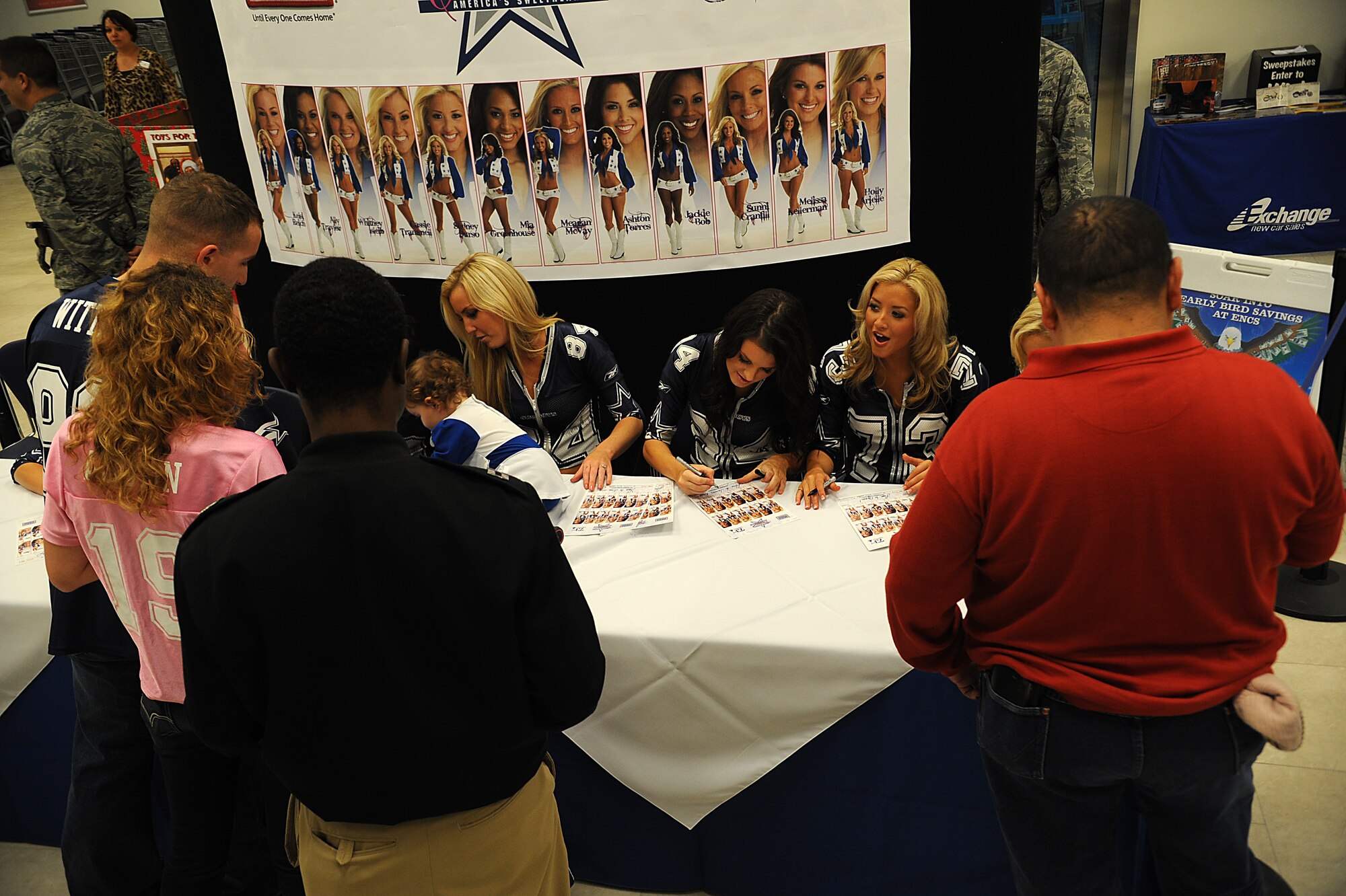 The Dallas Cowboys Cheerleaders sign autographs and talk to fans during a visit to the Exchange on Kadena Air Base, Japan, Dec. 15, 2011. The Dallas Cowboys Cheerleaders visited Kadena as part of their 73rd United Services Organization tour, where they are visiting 21 installations across the Pacific. (U.S. Air Force photo by Staff Sgt. Christopher Hummel/Released)