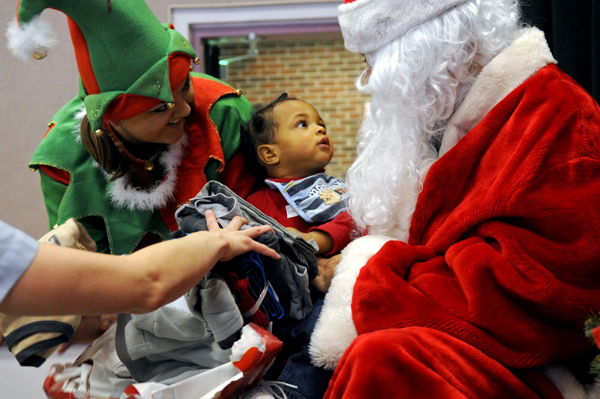 BARKSDALE AIR FORCE BASE, La. -- A child looks up at Santa Claus after opening his gift during Barksdale's Santas in Blue Christmas party held at the Bossier City Civic Center in Bossier City, La., Dec. 17. SIB is a committee formed by Barksdale's Top Three organization, which teamed up with the Department of Children Family Services to provide gifts for more than 400 children in foster care. Each child received three gifts. (U.S. Air Force photo/Senior Airman La'Shanette V. Garrett)(RELEASED)