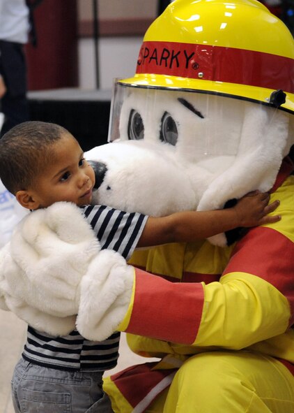 BARKSDALE AIR FORCE BASE, La. -- A child hugs Sparky the Fire Dog during Barksdale's Santas in Blue Christmas party held at the Bossier City Civic Center in Bossier City, La., Dec. 17. The children and their families also had the chance to visit with Santa Claus and his elves, and Airman Andy. (U.S. Air Force photo/Senior Airman La'Shanette V. Garrett)(RELEASED)