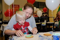 Chloe Saxton decorates a cookie with the help of her mother at Breakfast with Santa
Dec. 10. (U.S. Air Force photo/Don Lindsay)