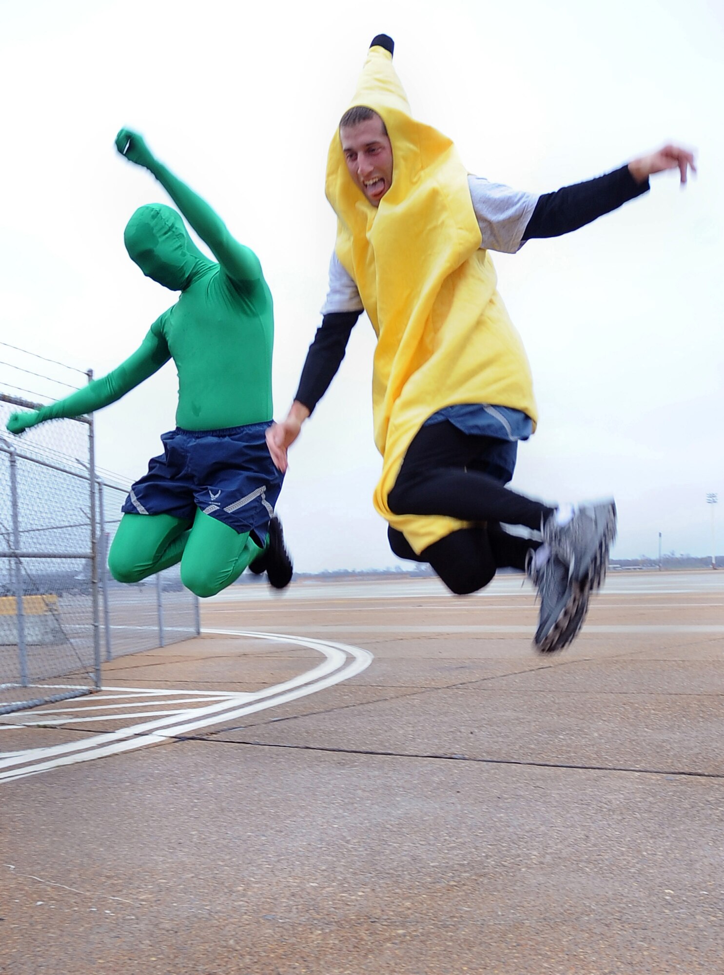 Senior Airman John Nearhood (left) and Staff Sgt. Jonas Selman (right), 2nd Civil Engineer Squadron, celebrate as they cross the finish line Dec. 16 during the Ham Haul Fun Run at the flightline on Barksdale Air Force Base, La. More than 80 Airmen participated in the approximate three-mile run wearing warm AF physical training gear, though a few varied the styling for morale. (U.S. Air Force photo/Senior Airman Amber Ashcraft)(RELEASED)