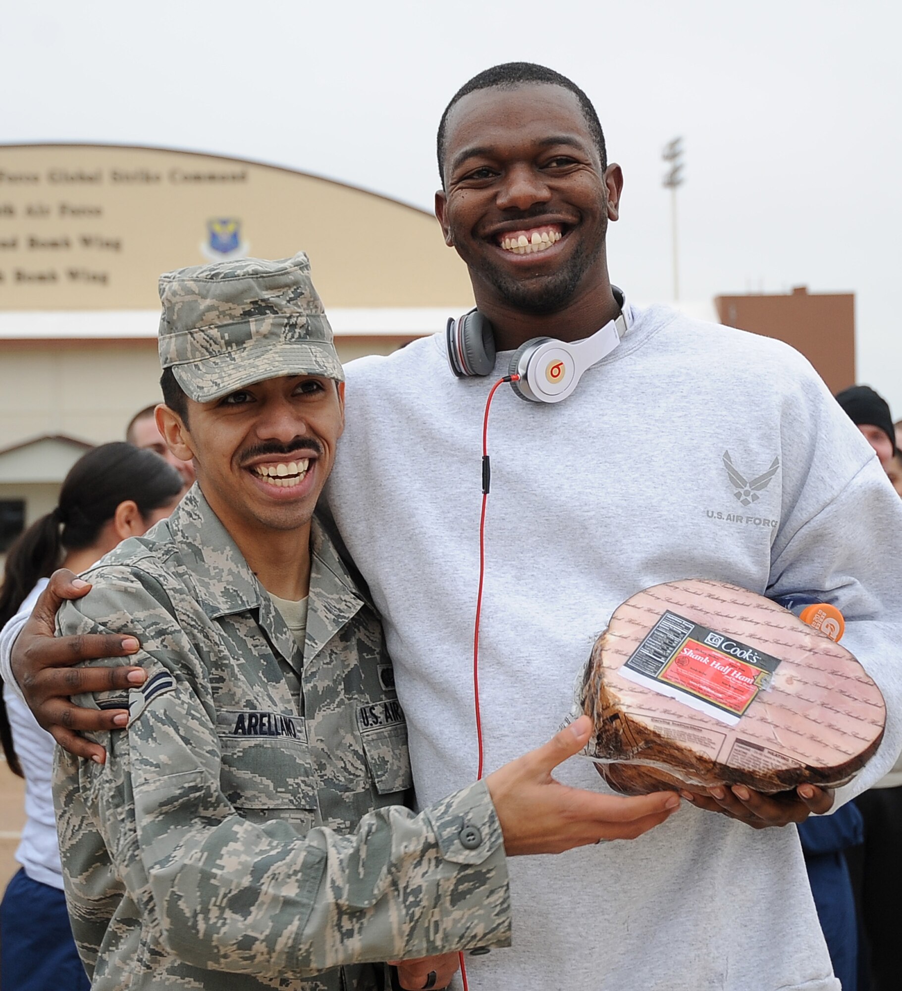 Airman 1st Class Braulio Arellano, 2nd Force Support Squadron, passes a ham to Staff Sgt. Wesley Devine, 2nd Operations Support Squadron, after the Ham Haul Fun Run Dec. 16 at the flightline on Barksdale Air Force Base, La. Prizes, raffled off after the completion of the run, included 30 hams, a digital camera set, portable DVD kit and several workout kits. (U.S. Air Force photo/Senior Airman Amber Ashcraft)(RELEASED)