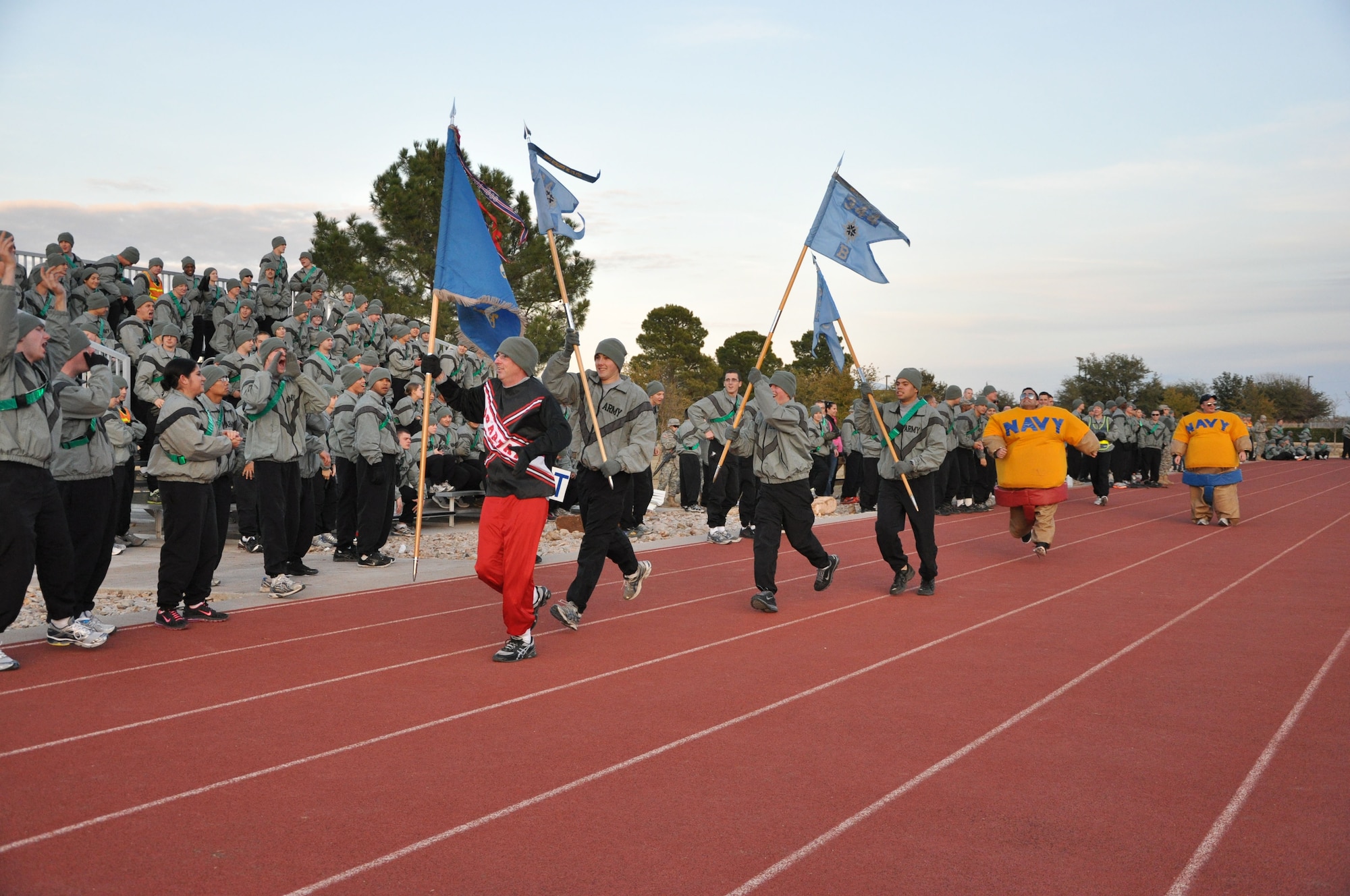 GOODFELLOW AIR FORCE BASE, Texas – U.S. Army guidon bearers from the 344th Military Intelligence Battalion rally up Soldiers during the Third Annual Army versus Navy flag football game at the base field Dec. 17. Hundreds of base members gathered to support their team. (U.S. Air Force photo/ Staff Sgt. Tong Duong)