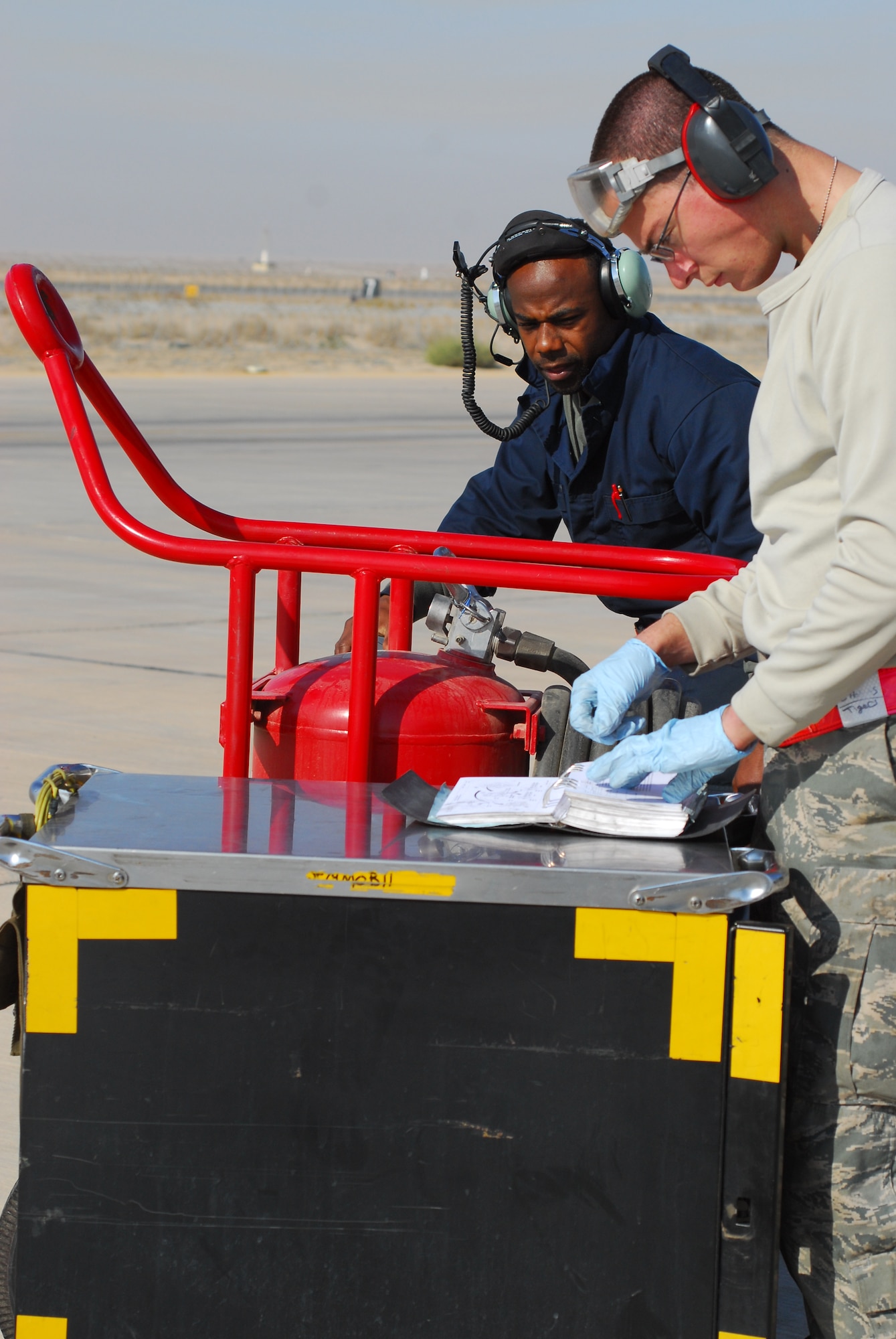 Staff Sgt. Manuel Beckett and Senior Airman Caleb Holmes, 332nd Expeditionary Aircraft Maintenance Squadron crew chiefs, complete checklists after the return of F-16 Fighting Falcons flown in conjunction with the final combat mission over Iraq Dec. 18, 2011. Beckett is a native of Hampton, S.C., and Holmes is a native of Camp Bell, N.Y. They are both deployed from Shaw Air Force Base, S.C. (U.S. Air Force photo/1st Lt. Rusty Ridley)