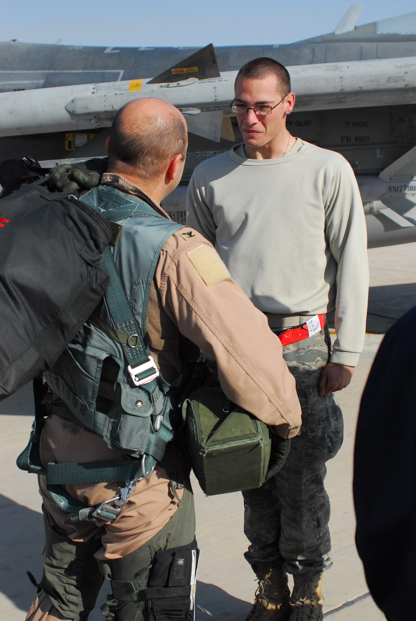 Col. Rodney Petithomme, 332nd Expeditionary Operations Group commander, speaks with Senior Airman Caleb Holmes, 332nd Aircraft Maintenance Squadron crew chief, after piloting the last combat mission over Iraq Dec. 18, 2011. Petithomme is a native of Angels Camp, Calif. and is deployed from Osan Air Base, Republic of Korea. Holmes is a native of Camp Bell, N.Y., and is deployed from Shaw Air Force Base, S.C. (U.S. Air Force photo/1st Lt. Rusty Ridley)
