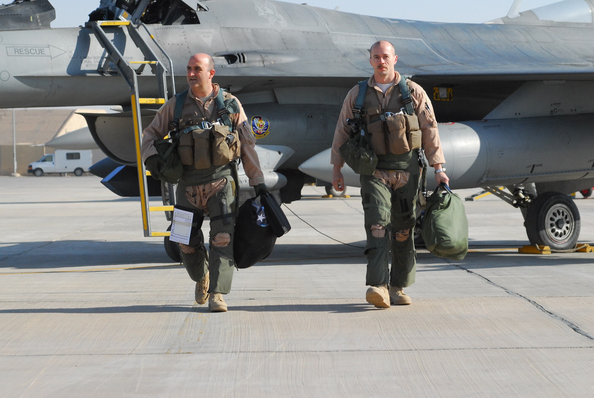 Col. Rodney Petithomme, 332nd Expeditionary Operations Group commander, and Lt. Col. Jason Plourde, 79th Expeditionary Fighter Squadron commander, walk off the flightline after piloting the last two combat aircraft over Iraq Dec. 18, 2011. Flying F-16s, they provided top cover for the last convoys leaving the country. Petithomme is a native of Angels Camp, Calif., and is deployed from Osan Air Base, Republic of Korea. Plourde is a native of Hermon, Maine, and is deployed from Shaw Air Force Base, S.C. (U.S. Air Force photo/1st Lt. Rusty Ridley)
