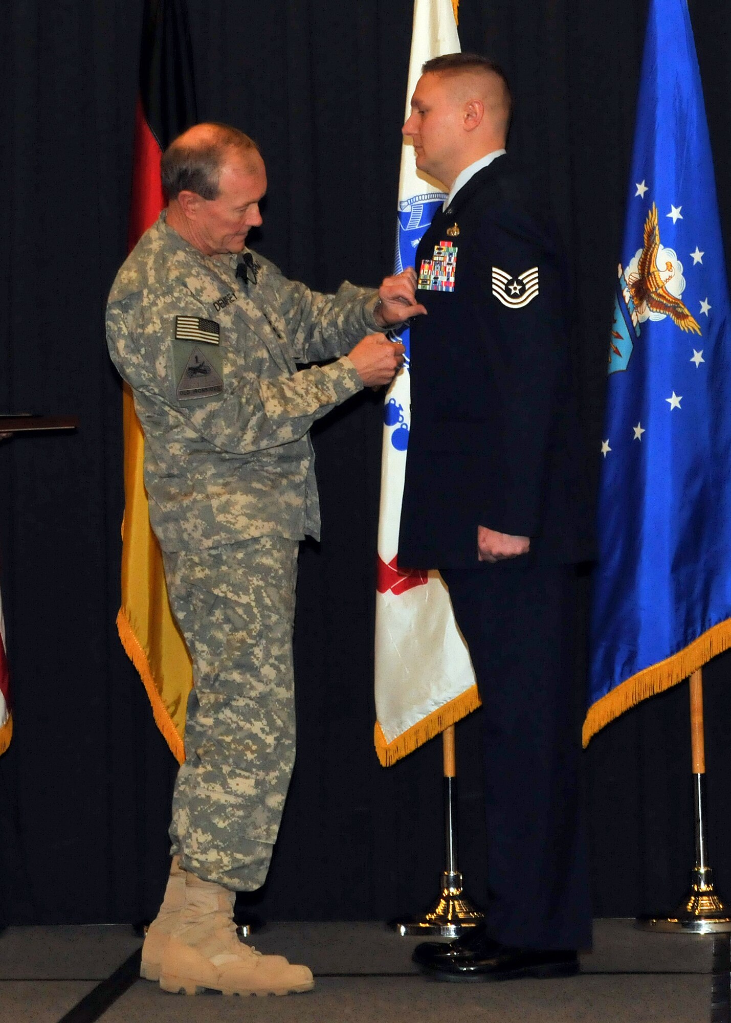 RAMSTEIN AIR BASE, Germany -- Chairman of the Joint Chiefs of Staff, Gen. Martin E. Demplsey presents a Purple Heart medal to Tech. Sgt. Richard Chwalik, Headquarters U.S. Air Forces in Europe A4 command equipment manager, Dec. 19 at a town hall meeting during the chairman's visit here.  Chwalik was injured during his deployment to Afghanistan in 2009. (U.S.Air Force photo by Tech. Sgt. Markus M. Maier/Relased)