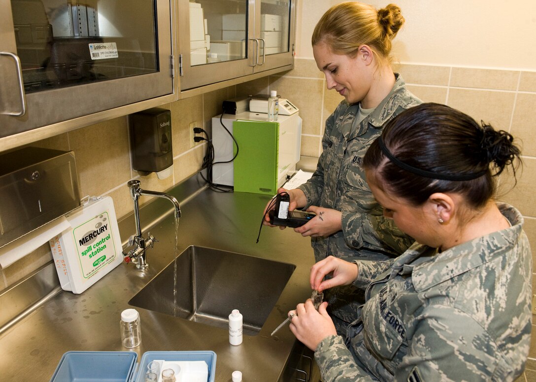 Airmen 1st Class Lauren Allen and Spencer Hearn, 28th Medical Operations Squadron bioenvironmental engineer technicians, test drinking water on Ellsworth Air Force Base, S.D., Nov. 30, 2011. The hach water testing kit measures chlorine and PH levels in drinking water to ensure it’s safe for all Ellsworth families. (U.S. Air Force photo by Airman Alystria Maurer/Released)