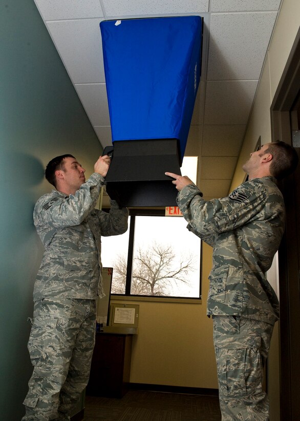 Staff Sgts. Aaron Waite and Jon Andrew, 28th Medical Operations Squadron bioenvironmental engineer technicians, uses a balometer to measure air flow in the 28th Medical Group building on Ellsworth Air Force Base, S.D., Nov. 30, 2011. This procedure checks ventilation systems for sufficient airflow to ensure a healthy and safe environment for patients and staff. (U.S. Air Force photo by Airman Alystria Maurer/Released)