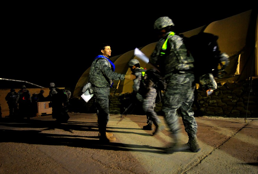 Col. Ted Mathews shakes the hand the Airmen under his command Dec. 18, 2011, before they board a C-17 Globemaster III at Ali Air Base, Iraq. Mathew's Airmen were the last Airmen to redeploy from Iraq. Mathews is the 407th Air Expeditionary Group commander. (U.S. Air Force photo/Master Sgt. Cecilio Ricardo)