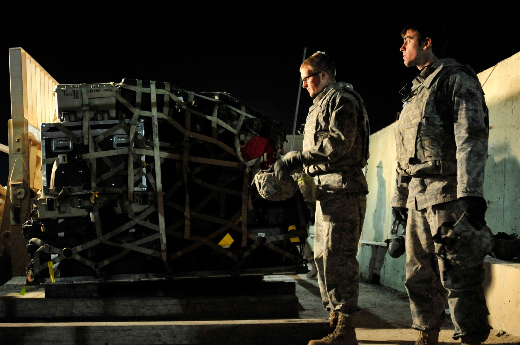 Senior Airman Nicholas Olsen and Airman 1st Class Justin Smith prepare the last pallet to be transported from Ali Air Base, Iraq, Dec. 18, 2011. The Airmen are the last service members to redeploy from Iraq based on the Iraq and U.S. 2008 Security Agreement that required all U.S. service members to be out of the country by Dec. 31. Olsen and Smith are aerial porters assigned to the 407th Air Expeditionary Group. (U.S. Air Force photo/Master Sgt. Cecilio Ricardo)