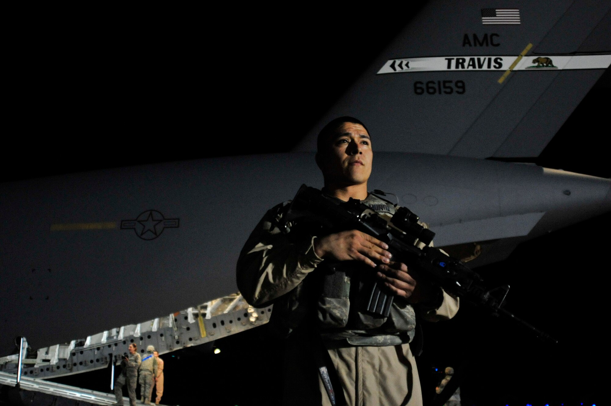 Staff Sgt. Gerardo Munoz guards a C-17 Globemaster III that will transport the last Airmen from Iraq on Dec. 18, 2011, at Ali Air Base, Iraq. Munoz is a security forces member assigned to the 385th Air Expeditionary Group. (U.S. Air Force photo/Master Sgt. Cecilio Ricardo)