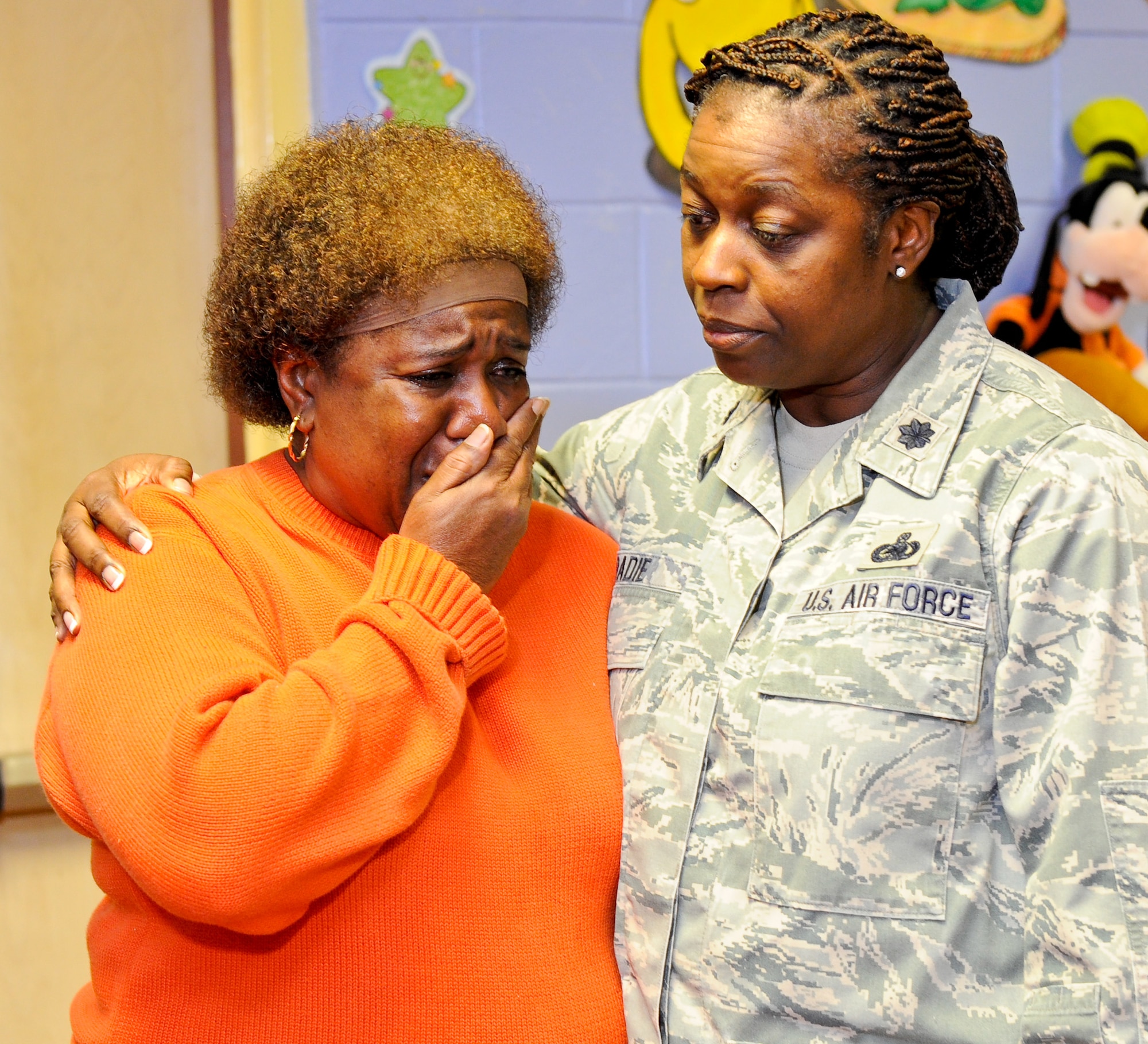 Lt. Col. Gwendolyn Badie, 116th Force Support Squadron commander, Robins Air Force Base, Ga., hugs Mary Harris after presenting her with a check from the Family-2-Family project at Pearl Stephens Elementary school, Warner Robins, Ga., Dec. 9, 2011.  The annual project, coordinated by the 116th and 461st Air Control Wings, provides food and toys to community and military families for the holidays.  A special donation was given to Harris to help with expenses incurred when she lost her home during a fire.  (National Guard photo by Master Sgt. Roger Parsons/Released)