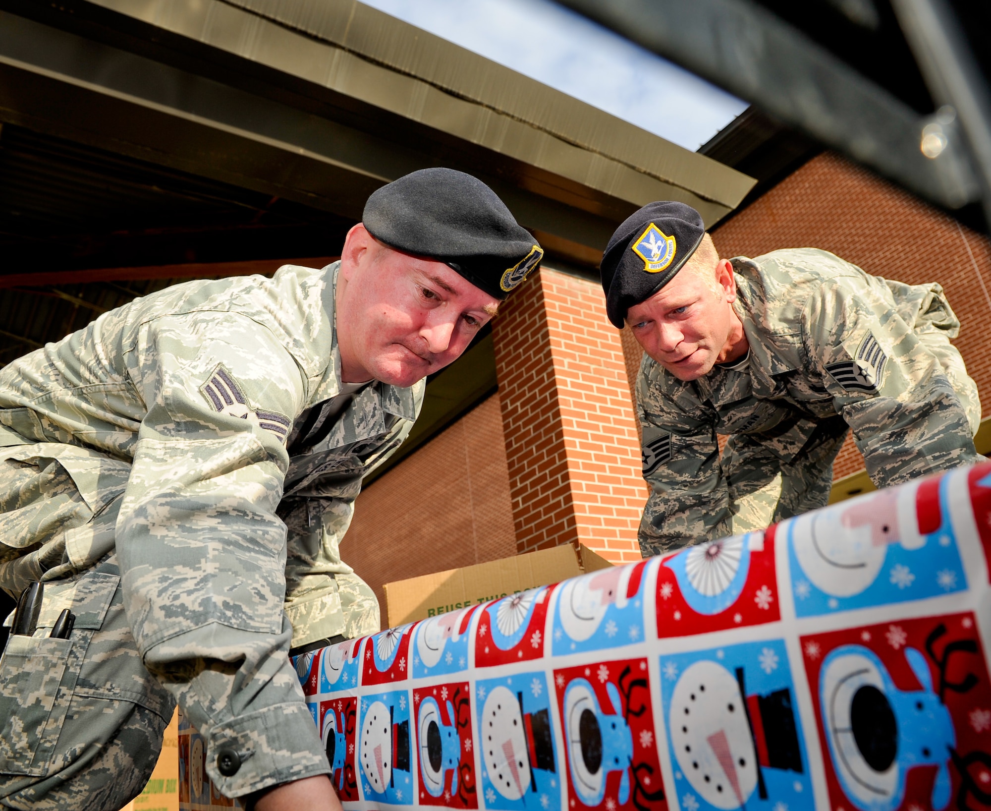 Senior Airman Aaron Wray, left, and Staff Sgt. Robert Gassman, 116th Security Forces Squadron, load a truck with presents donated for the Family-2-Family project, Robins Air Force Base, Ga., Dec. 9, 2011.  The annual project, coordinated by the 116th and 461st Air Control Wings, provides food and toys to community and military families for the holidays.  (National Guard photo by Master Sgt. Roger Parsons/Released)