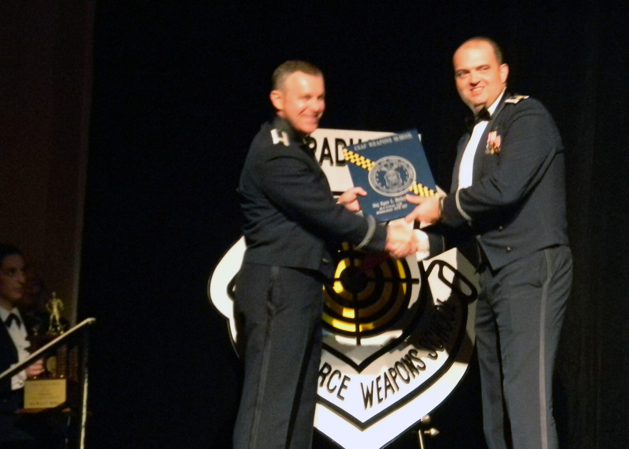 B-2 bomber pilot Maj Ryan "Poacher" Bailey, 131st Bomb Wing, Missouri Air National Guard, receives his  U.S. Air Force Weapons School graduation plaque on stage at the Flamingo Hotel and Casino, Dec 10.   He received the additional honor of being awarded Outstanding Graduate of his class.  (Air National Guard Courtesy Photo)

