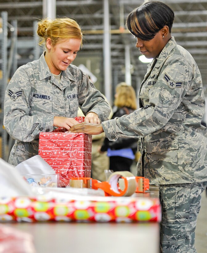 Senior Airman Ashli McDaniels, left, and Airman 1st Class Natasha Scott, 116th Air Control Wing (ACW), wrap a toy donated for the Family-2-Family project, Robins Air Force Base, Ga., Dec. 9, 2011.  The annual project, coordinated by the 116th and 461st ACW, provides food and toys to community and military families for the holidays.  (National Guard photo by Master Sgt. Roger Parsons/Released)