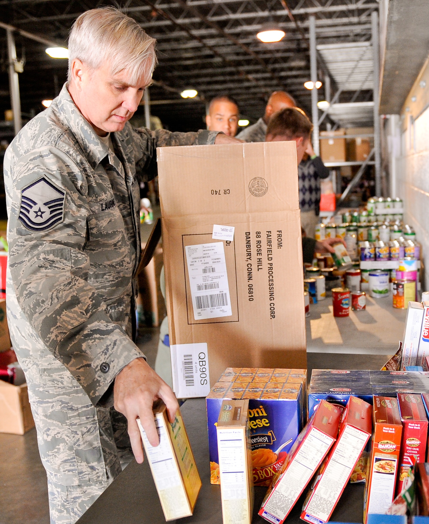 Air National Guard Master Sgt. Lawrence Laurine, 116th Air Control Wing (ACW), unloads a box of food donated for the Family-2-Family project, Robins Air Force Base, Ga., Dec. 9, 2011.  The annual project, coordinated by the 116th and 461st ACW, provides food and toys to community and military families for the holidays.  (National Guard photo by Master Sgt. Roger Parsons/Released)