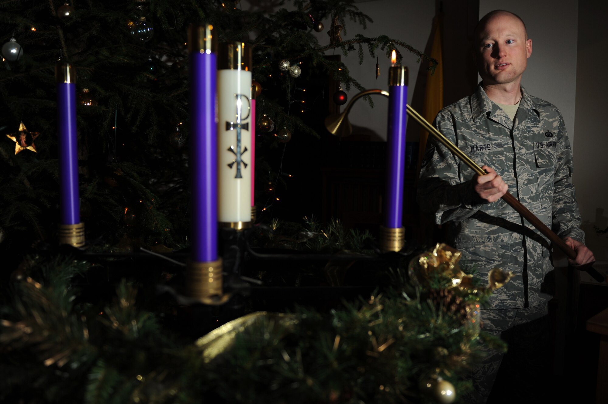 SPANGDAHLEM AIR BASE, Germany -- Staff Sgt. Brian Marts, 52nd Fighter Wing chaplain assistant, lights a candle on an Advent wreath inside the base chapel here Dec. 14. Chaplain assistants assist chaplains in facilitating the free exercise of religion for Airmen and their families. The chapel provides programs to nurture spiritual fitness to include services, studies and gatherings. (U.S. Air Force photo/ Airman 1st Class Matthew B. Fredericks)