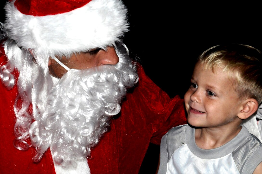 ANDERSEN AIR FORCE BASE, Guam—A child visits with Santa Claus during Andersen’s Rota here, Dec. 17. The Rota Walk had candy, lights, fake snow and costumed characters for the participants to enjoy during the holiday season.  (U.S. Air Force photo by Senior Airman Benjamin Wiseman/Released)