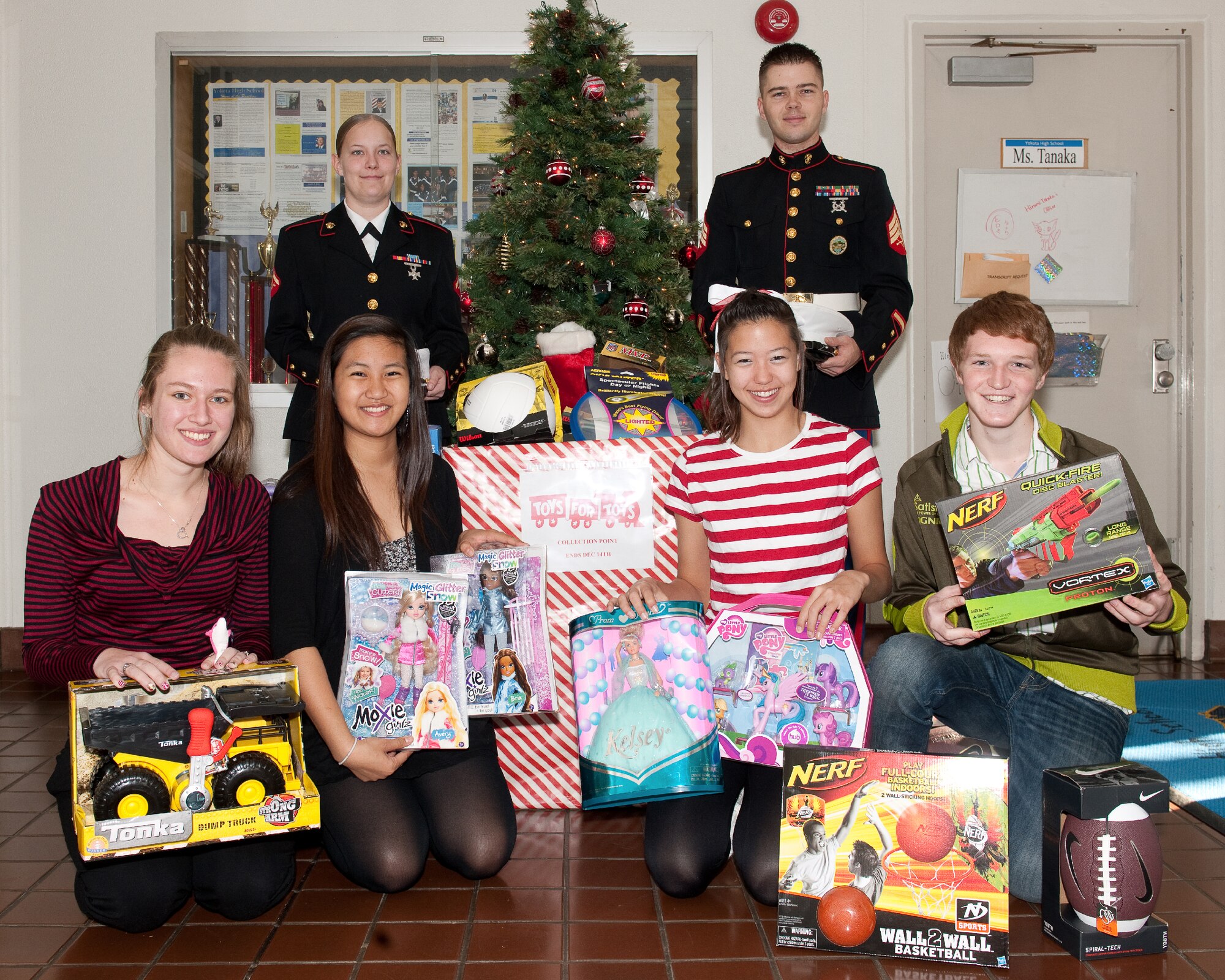 YOKOTA AIR BASE, Japan -- (front left to right) Yokota High School Seniors, Kathryn White, Aryssa Livica, Kimberly Blair, and Johnny Cope and (top left to right) Lance Cpl. Crystal Green, American Forces Network Tokyo, and Sgt. Timothy Johnston, U.S. Forces Japan, pose for a photo with toys collected for the Toys for Tots program, Dec. 15, 2011, Yokota Air Base, Japan. Toys for Tots is a U.S. Marine Corps Reserve program that is designed for the collection of new, unwrapped toys during October, November and December each year, for distribution of those toys as gifts to needy children in the community during the holiday season. Marines at Yokota AB distributed the toys collected to children at local orphanages. (U.S. Air Force photo/Osakabe Yasuo)
