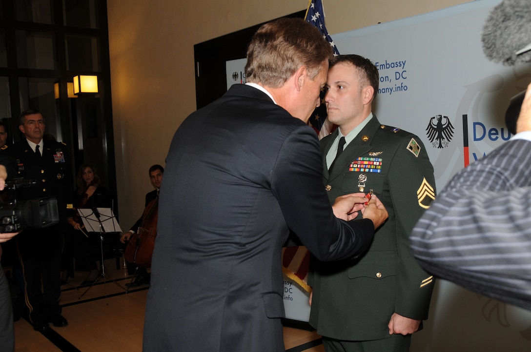 German Ambassador Peter Ammon presented U.S. Army Staff Sgt. Peter Woken with the German Medal of Honor for Gallantry in Action, which is similar to the American Silver Star, during a ceremony at the ambassador's home in Washington, D.C., Dec. 8, 2011. U.S. Army photo by C. Todd Lopez