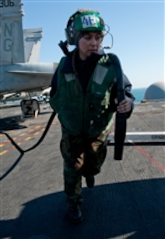 U.S. Navy Airman Sandra Leonard carries a power cord to route electrical power to an aircraft on the flight deck of the aircraft carrier USS John C. Stennis (CVN 74) in the Persian Gulf on Dec. 13, 2011.  The John C. Stennis is deployed to the U.S. 5th Fleet area of responsibility conducting maritime security operations and support missions as part of Operations Enduring Freedom and New Dawn.  