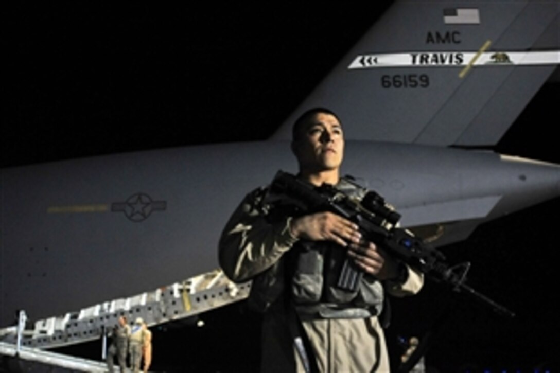 U.S. Air Force Staff Sgt. Gerardo Munoz guards a C-17 Globemaster III cargo aircraft, which will transport the last airmen out of Ali Air Base, Iraq, Dec. 18, 2011. Munoz is assigned to the 385th Air Expeditionary Group Security Forces, deployed from 319th Security Forces Squadron, Grand Forks Air Force Base, N.D.