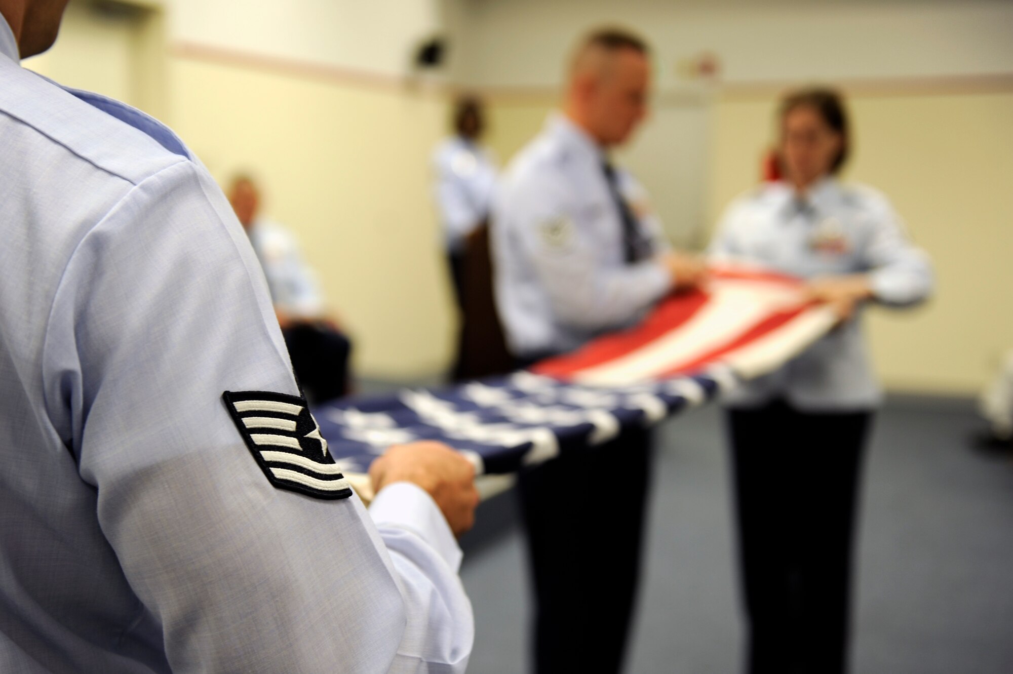 Flag detail members fold the American flag during the rededication of the Erwin Professional Military Education Center on Kadena Air Base, Japan, Dec. 16, 2011. The project's planning and preparation began in 2002. (U.S. Air Force photo by Airman 1st Class Maeson L. Elleman/Released)