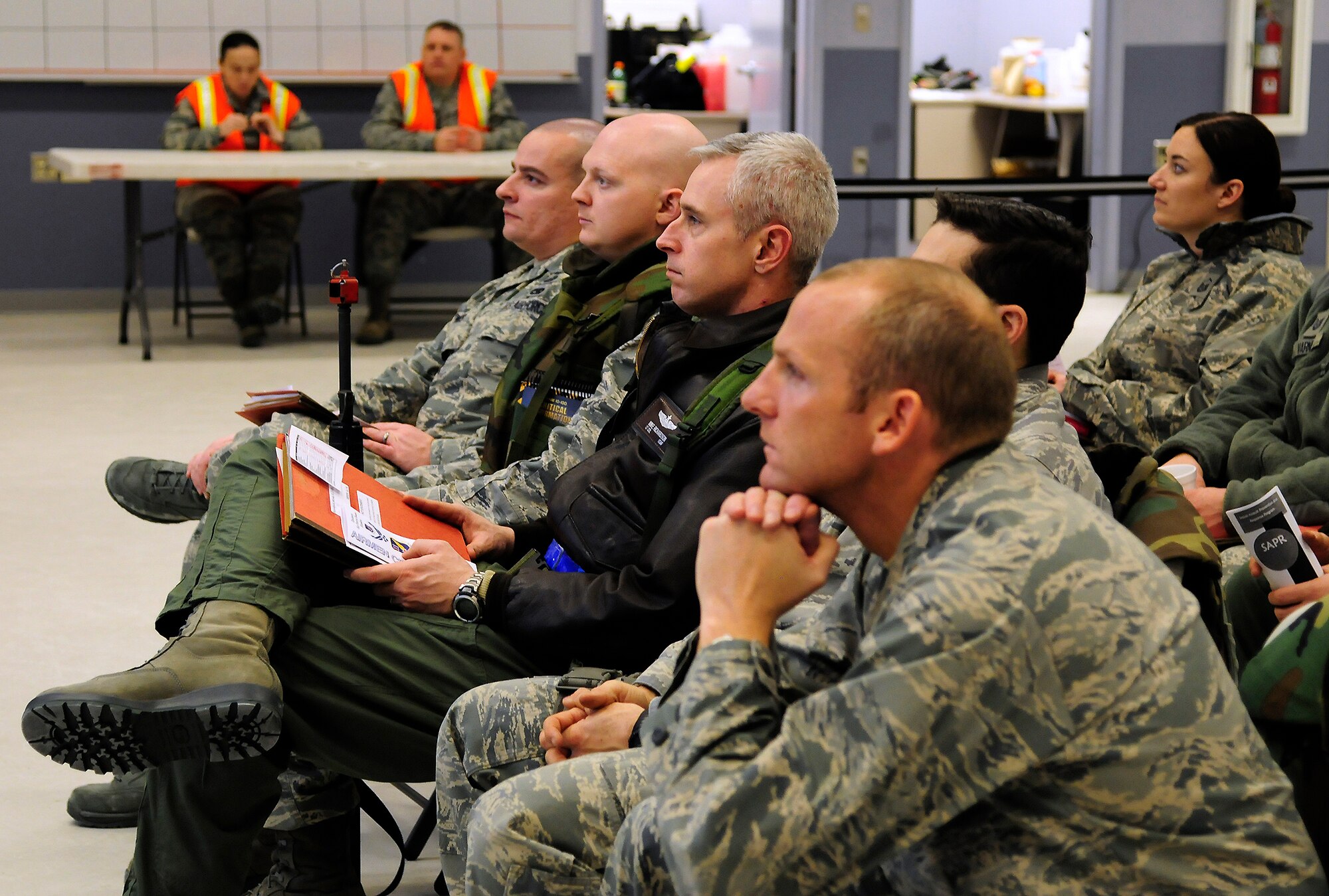 U.S. Airmen are given a pre-deployment briefing during an Operational Readiness Exercise at the Joint Mobility Complex, Dec. 14, 2011, Eielson Air Force Base, Alaska. The briefing covered topics such as settling finances and maintaining health and wellness while deployed. (U.S. Air Force photo by Airman 1st Class Yash Rojas/Released)