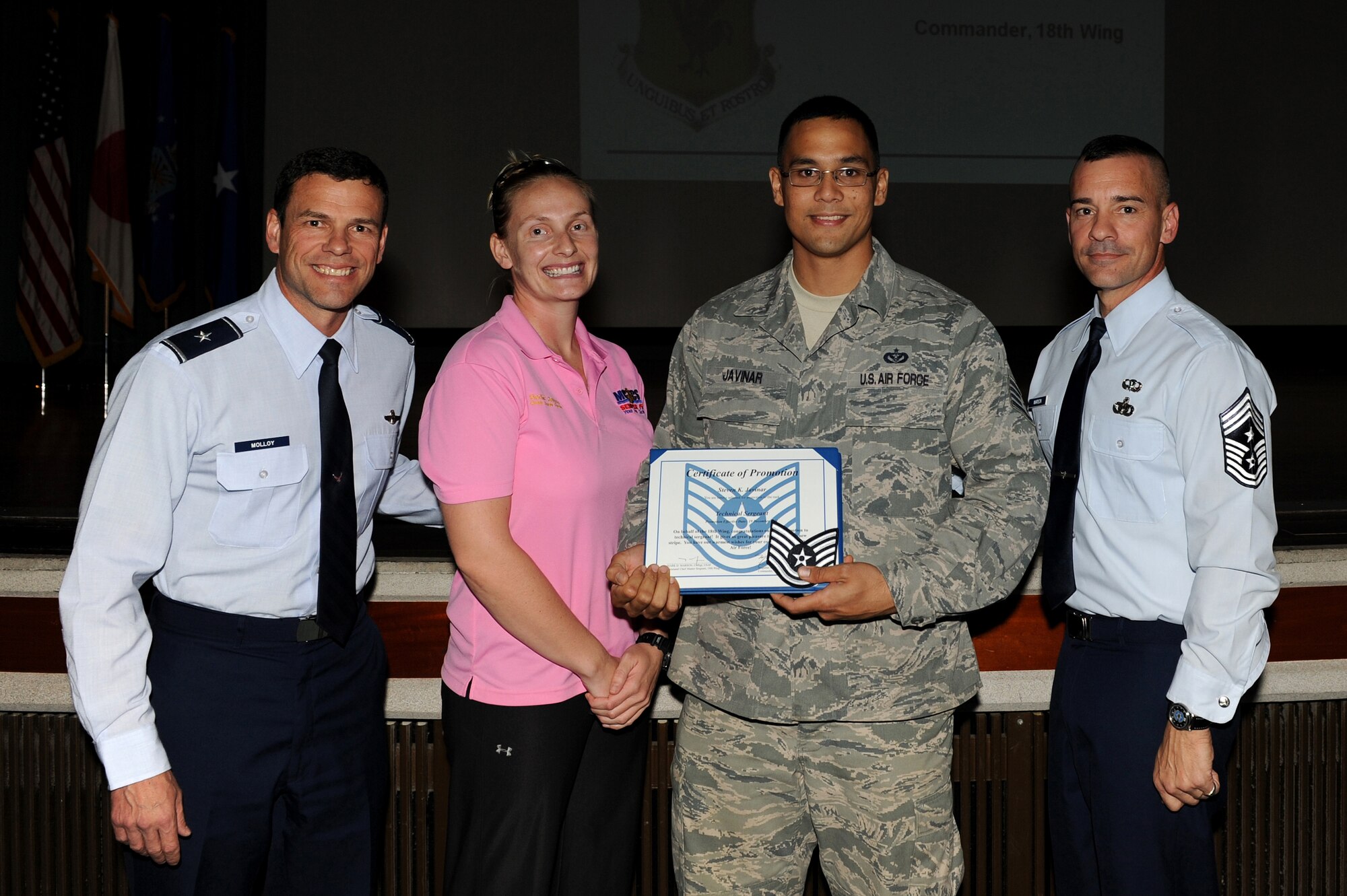U.S. Air Force Staff Sgt. Steven Javinar, 18th Civil Engineer Squadron water fuel systems maintainer, receives a Stripes for Exceptional Performers promotion from U.S. Air Force Brig. Gen. Matt Molloy, 18th Wing commander, and Chief Master Sgt. Mark Marson, 18th Wing command chief, at a holiday safety briefing, Dec. 19, 2011, on Kadena Air Base, Japan. Javinar and U.S. Air Force Staff Sgt. Sovanna Tanner, 18th Contracting Squadron specialist, were immediately promoted to technical sergeant for their exceptional performance and achievements. (U.S. Air Force photo by Junko Kinjo/Released)