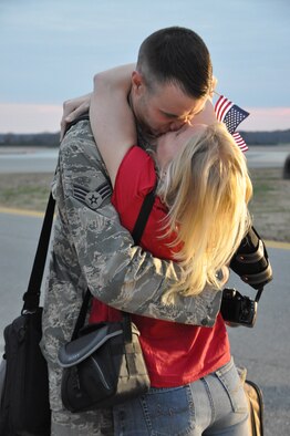 Senior Airman Keith Holman shares a kiss with his wife, Linley, after returning home to Seymour Johnson Air Force Base, N.C., Dec. 20, 2011. Holman is one of approximately 100 Seymour Johnson Airmen returning home before the holidays. Holoman deployed to Bagram Airfield, Afghanistan, and is a 335th Aircraft Maintenance Unit avionics specialist. (U.S. Air Force photo by Airman 1st Class Mariah Tolbert)