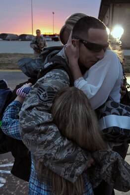 Staff Sgt. Robert Abolos, 335th Aircraft Maintenance Unit weapons specialist, hugs his wife Beverly and daughter Alyssa on Seymour Johnson Air Force Base, N.C., Dec. 20, 2011. Abolos was greeted by a crowd of family and friends with fellow Airmen returning home from Bagram Airfield, Afghanistan, just days before the holidays. (U.S. Air Force photo by Airman 1st Class Mariah Tolbert)