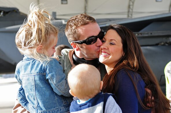 Capt. Josh Higgins, 335th Fighter Squadron F-15E Strike Eagle pilot, shares a hug and a kiss with his wife and two children after returning to Seymour Johnson Air Force Base, N.C., Dec. 20, 2011. More than 100 Seymour Johnson Airmen will be home from a deployment to Bagram Airfield, Afghanistan in the next few days. The Higgins' family is from Carthage, Texas. (U.S. Air Force photo by Senior Airman Rae Perry)