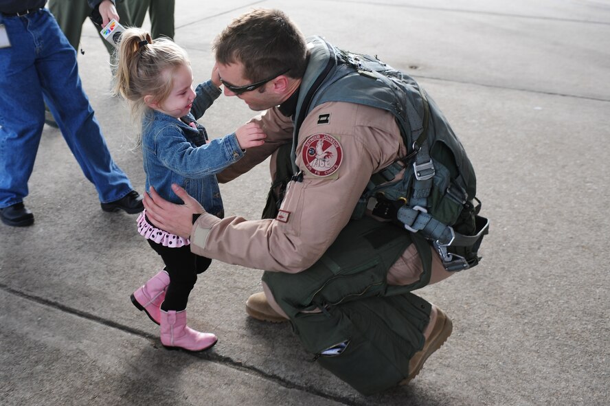 Capt. Josh Higgins, 335th Fighter Squadron F-15E Strike Eagle pilot, hugs his two-year-old daughter, Sagen, after returning to Seymour Johnson Air Force Base, N.C., Dec. 20, 2011. Twelve Strike Eagles and more than 80 support Airmen will return from a deployment to Bagram Airfield, Afghanistan over the next few days. Higgins is a native of Carthage, Texas. (U.S. Air Force photo by Senior Airman Rae Perry)