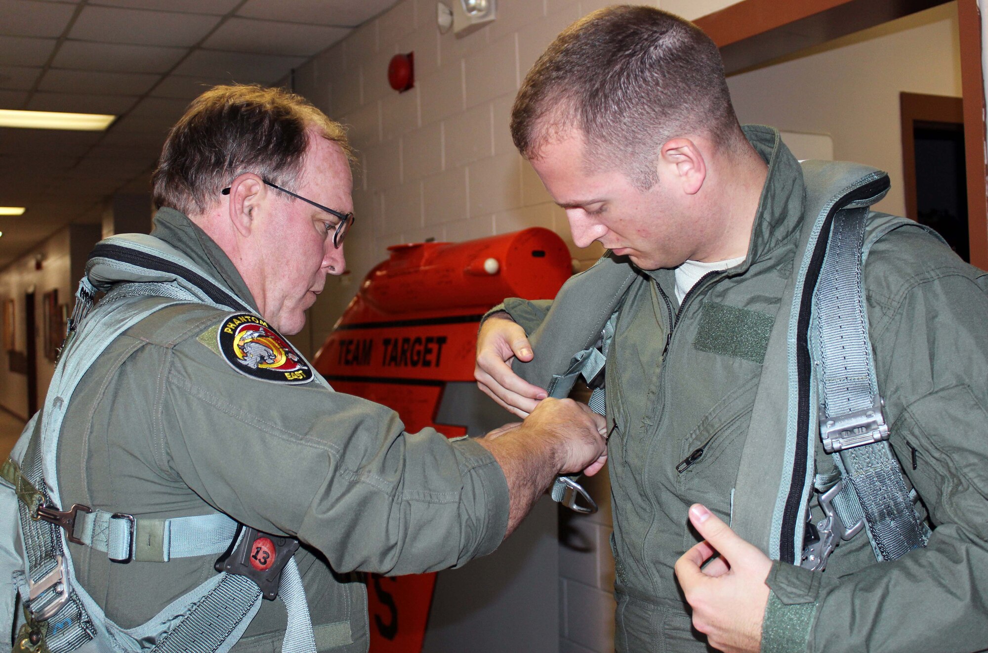 Mike MacWilliam, a pilot from the 53rd Weapons Evaluation Group, helps Staff Sgt. Stephen McGuire, a command and control systems administrator from the 601st Air and Space Operations Center, put on his flight gear at Tyndall Air Force Base, Fla., Dec. 15. McGuire, who was the 601st AOC’s Airman of the Year, received an incentive flight in an F-4 as part of a new initiative designed to provide more rewards to the command’s top enlisted performers. (U.S. Air Force photo by Angela Pope)