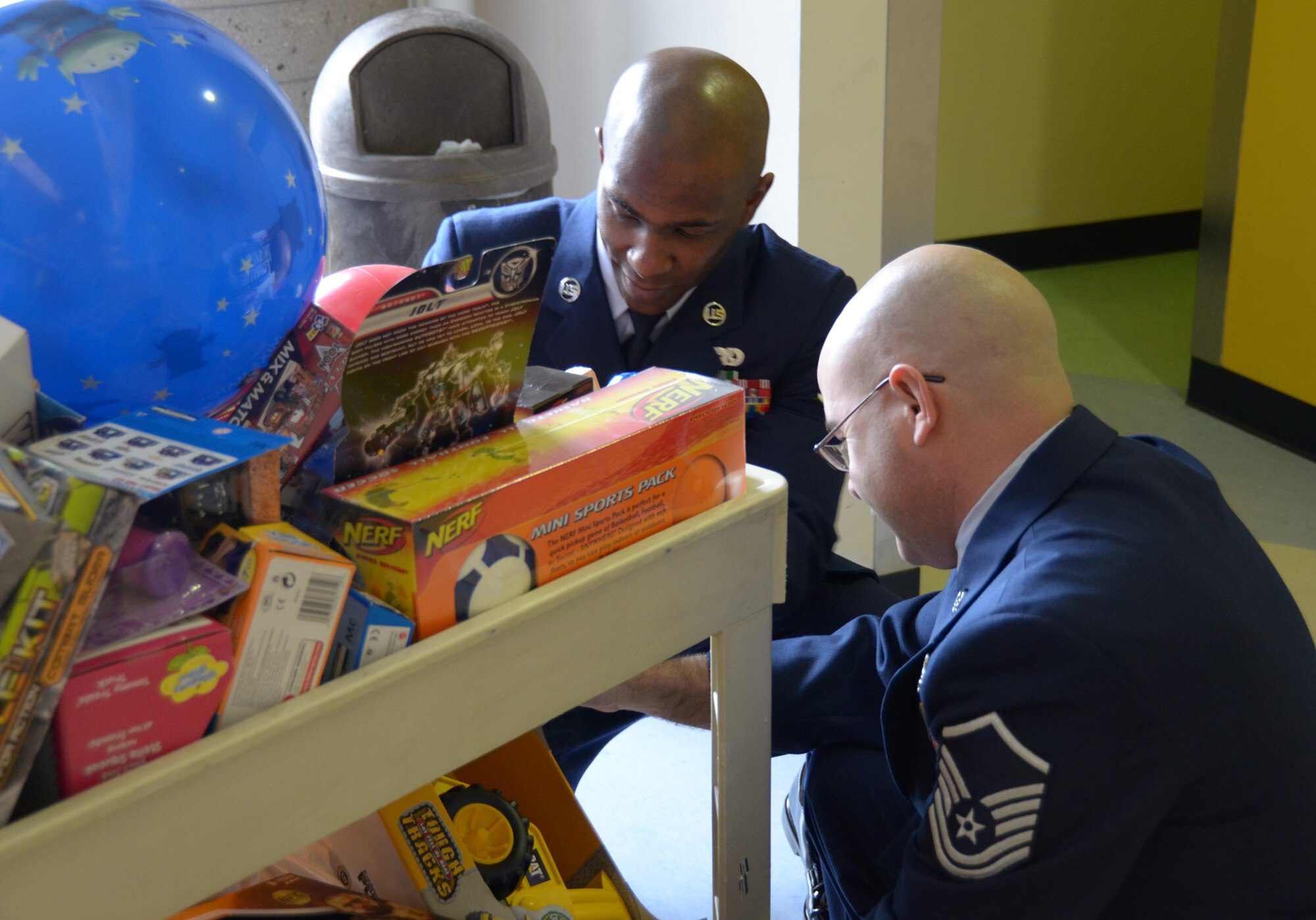 WRIGHT-PATTERSON AIR FORCE BASE, Ohio - Staff Sgt. Justin George (top) and Master Sgt. Paul Wright, members of the 445th Airlift Wing’s 87th Aerial Port Squadron, load a cart with toys and other gifts prior to delivery to patients at the Dayton Children’s Hospital Dec. 16. 87APS members have worked with the hospital for more than 22 years to bring a little more happiness to children who are hospitalized there over the holidays. (U.S. Air Force photo/Capt. John Stamm)