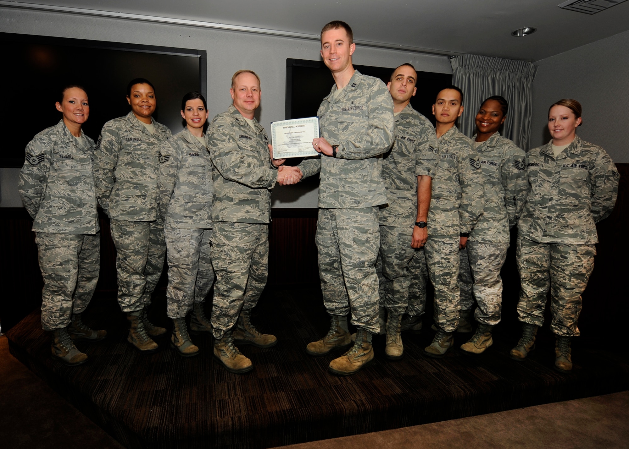Capt Brandon Bennett, Schriever Dental Clinic officer in charge, receives the November Gold Knight award Dec. 14 from Col. Chris Crawford, 21st Space Wing commander. (U.S. Air Force photo/Rob Bussard)