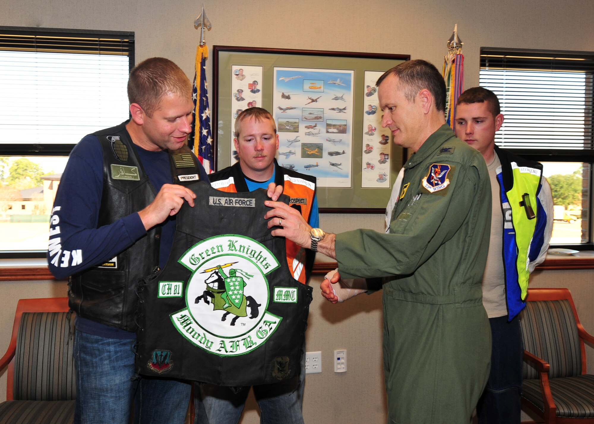 U.S. Air Force Tech. Sgt. Daniel Fleig, 23rd Comptroller Squadron budget analyst and president of the Green Knights motorcycle club presents the club colors to Col. Billy Thompson, 23rd Wing commander, making him an honorary member at Moody Air Force Base, Ga., Dec. 19, 2011. The Green Knights is open to anyone affiliated with the military and enjoys motorcycle riding. The club currently has 15 members; they ride every weekend.  (U.S. Air Force photo by Staff Sgt. Stephanie Mancha/Released)
